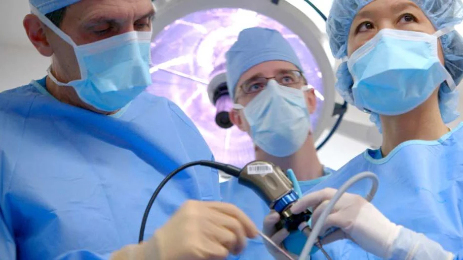Photo of three doctors performing surgery 